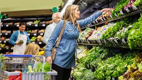 een vrouw aan de groentebalie met haar dochter